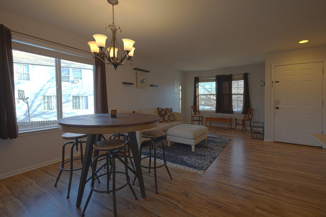 Dining table with stools beneath a chandelier