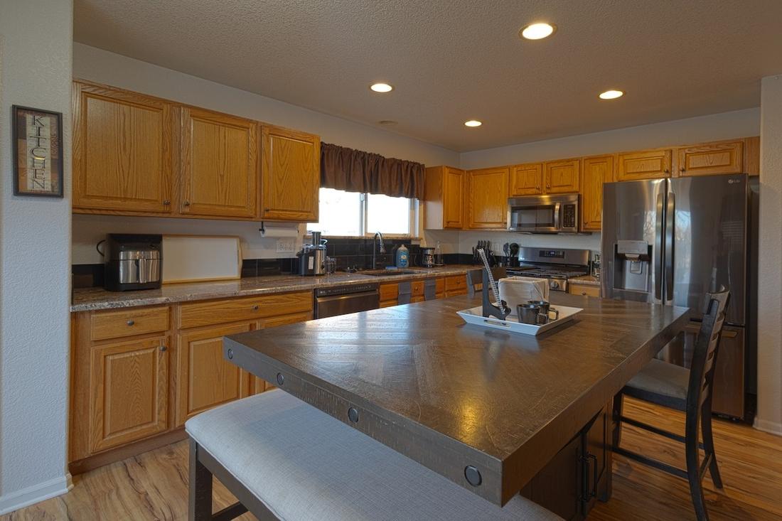 Kitchen with stainless appliances and a large island table